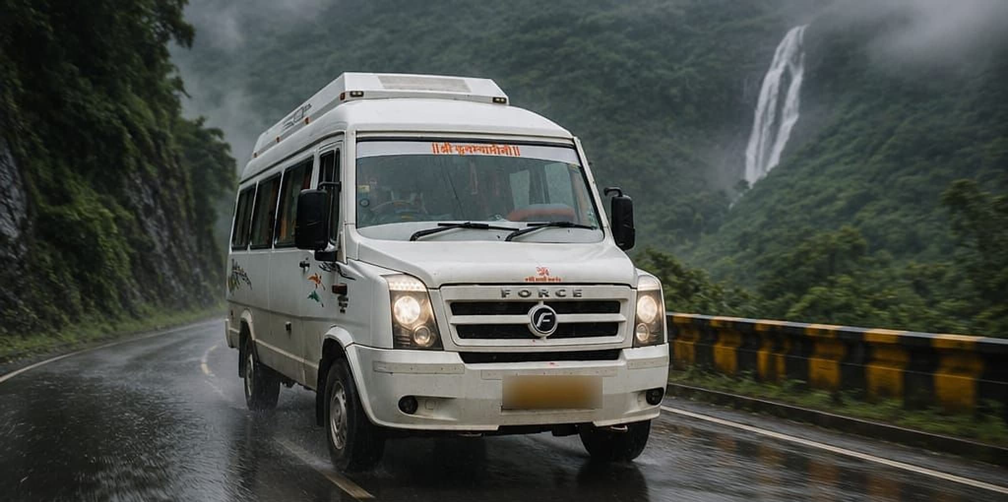 The Kalika Yatra Traveller driving on a wet ghat road, with a waterfall on the hillside behind