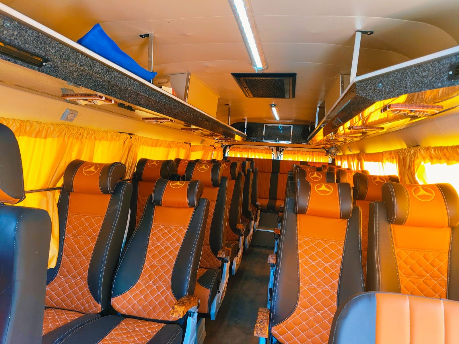 Rows of orange and dark-brown leather push-back seats inside the Traveller, with yellow curtains